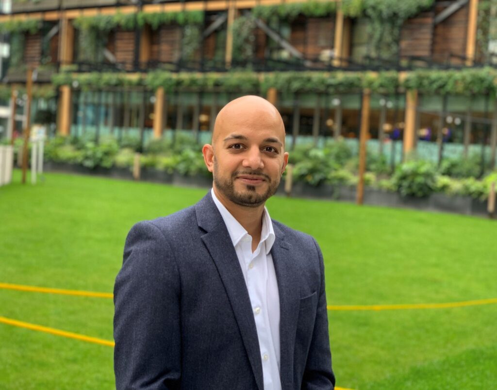 Sim Sekhon in a field smiling for the camera